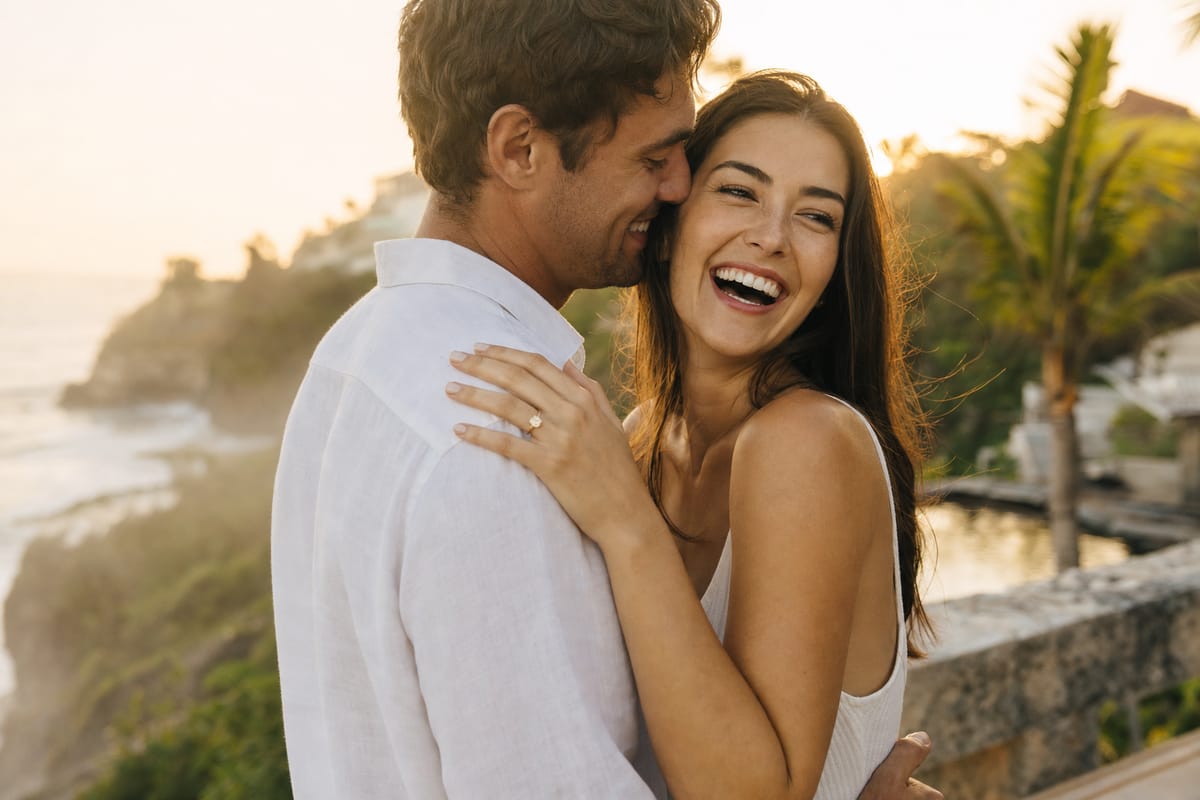 A newly engaged couple embracing at golden hour in Bali