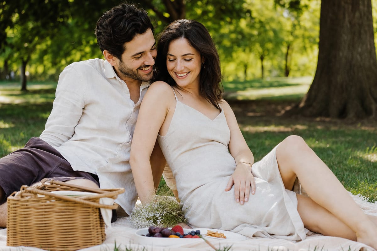 A couple relaxed and laughing together on a picnic blanket in a park